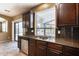 Kitchen features double sink, granite counters, and dark wood cabinets at 24710 N 27Th Pl, Phoenix, AZ 85024