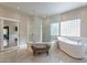 Spa-like bathroom with soaking tub, walk-in shower, and bench at 29306 N 70Th Way, Scottsdale, AZ 85266