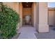 Home entry with a wood door, stone tile flooring and a vine-covered wall at 29306 N 70Th Way, Scottsdale, AZ 85266