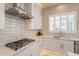 Modern kitchen with gas cooktop, white cabinets, and subway tile backsplash at 29306 N 70Th Way, Scottsdale, AZ 85266