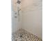 Walk-in shower with pebble floor and wave tile accent at 29306 N 70Th Way, Scottsdale, AZ 85266