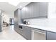 Modern kitchen features gray cabinetry, white countertops, and herringbone backsplash at 2942 N 81St Pl, Scottsdale, AZ 85251