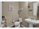 Clean bathroom with pedestal sink, toilet and shelf at 3667 E Angstead Ct, Gilbert, AZ 85296