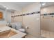 Beige tiled bathroom featuring a beige sink, toilet, mirror, and shower at 4024 E Hermosa Vista Dr, Mesa, AZ 85215