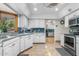 Bright white kitchen featuring blue tile backsplash, white cabinets, and stainless steel appliances at 4024 E Hermosa Vista Dr, Mesa, AZ 85215