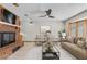 Cozy living room showcasing a brick fireplace, ceiling fan, and natural light from a window at 4024 E Hermosa Vista Dr, Mesa, AZ 85215