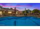 Sparkling swimming pool at dusk, surrounded by a patio, backyard, and mature landscaping at 4024 E Hermosa Vista Dr, Mesa, AZ 85215