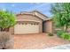 Tan house with a three-car garage and brick driveway at 4125 W Bradshaw Creek Ln, New River, AZ 85087