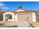 New construction home with a tan colored front facade and driveway at 414 E Eason Ave, Buckeye, AZ 85326