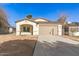 Newly built home with a tan colored front facade and driveway at 414 E Eason Ave, Buckeye, AZ 85326