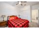 Cozy bedroom with a red and black plaid comforter and ceiling fan at 4524 S 127Th Ln, Avondale, AZ 85323