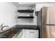 Modern kitchen with floating shelves, stainless steel sink, and subway tile at 4950 N Miller Rd # 347, Scottsdale, AZ 85251