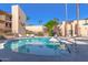 Community pool with surrounding lounge chairs at 4950 N Miller Rd # 347, Scottsdale, AZ 85251