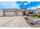 Single-story home with two-car garage, stone accents, and landscaped front yard at 5645 N Crow Dr, Eloy, AZ 85131