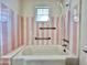 Bathroom with pink and white striped tile and a shower/tub combo at 5708 W Belmont Ave, Glendale, AZ 85301