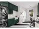 Modern laundry room with dark green cabinets, white subway tile, and a farmhouse sink at 6602 E Lafayette Blvd, Scottsdale, AZ 85251