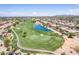 Aerial view of a residential area adjacent to a golf course and lake at 6616 S Bridal Vail Dr, Gilbert, AZ 85298