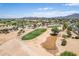 Aerial view of a golf course with a pond and homes in the background at 6616 S Bridal Vail Dr, Gilbert, AZ 85298