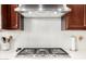 Stainless steel cooktop with overhead range hood at 6616 S Bridal Vail Dr, Gilbert, AZ 85298