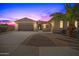 Beautiful desert home with three-car garage and landscaped front yard at sunset at 6616 S Bridal Vail Dr, Gilbert, AZ 85298