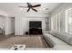 Spacious living room featuring a large TV, comfortable seating, and a ceiling fan at 6616 S Bridal Vail Dr, Gilbert, AZ 85298