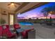 Relaxing backyard oasis with a sparkling pool and patio furniture under sunset at 6616 S Bridal Vail Dr, Gilbert, AZ 85298