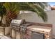 Built-in outdoor kitchen with stainless steel grill and mini-fridge at 7354 E San Miguel Ave, Scottsdale, AZ 85250