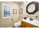 Elegant powder room featuring a wood vanity and octagonal mirror at 7354 E San Miguel Ave, Scottsdale, AZ 85250