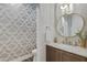 Stylish powder room featuring a unique patterned wall and marble vanity at 7483 S Loback Ct, Queen Creek, AZ 85142