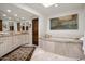 Luxurious bathroom with double vanity, soaking tub, and marble flooring at 7500 E Mccormick Pkwy # 63, Scottsdale, AZ 85258