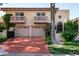 Two-car garage with a red brick driveway at 7500 E Mccormick Pkwy # 63, Scottsdale, AZ 85258