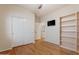 Secondary bedroom with hardwood floors and built-in shelving at 8429 W Salter Dr, Peoria, AZ 85382