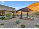 Desert landscaping with pergola, fire pit, and built-in seating at 8912 W Roberta Ln, Peoria, AZ 85383