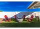 Relaxing firepit area with red chairs on the grassy lawn at 920 E 10Th Pl, Mesa, AZ 85203