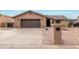 Single-story home with brown garage door and desert landscaping at 9543 E Palomino Pl, Sun Lakes, AZ 85248