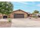 Tan house with brown garage door and landscaped yard at 9543 E Palomino Pl, Sun Lakes, AZ 85248