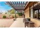 Pergola-covered patio with seating and lush greenery at 9543 E Palomino Pl, Sun Lakes, AZ 85248