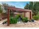 Relaxing water feature with pergola and lush greenery at 9543 E Palomino Pl, Sun Lakes, AZ 85248