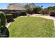Expansive backyard features lush lawn, mature landscaping, hardscape patio with lounging area and privacy wall at 11517 W Coral Snake Ct, Surprise, AZ 85378