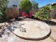Landscaped backyard with two red Adirondack chairs on dark soil and a curved stone tile platform at 11517 W Coral Snake Ct, Surprise, AZ 85378