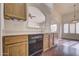 Kitchen boasts wood cabinets, dishwasher, and views to living room at 11517 W Coral Snake Ct, Surprise, AZ 85378