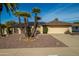 House exterior featuring a well-maintained lawn, solar panels and mature palm trees at 12526 W Skyview Dr, Sun City West, AZ 85375