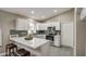 Modern kitchen with white cabinets, quartz countertops, and gray tile floors at 12533 W Windsor Ave, Avondale, AZ 85323