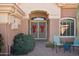 Front entry with decorative metal security doors and potted plants at 16013 W Sentinel Dr, Sun City West, AZ 85375