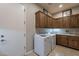 Spacious laundry room with wooden cabinets and washer/dryer at 1684 E Elysian Pass, Queen Creek, AZ 85140