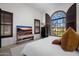 Bright bedroom with a large window, plantation shutters, and a TV at 20177 E Via De Arboles --, Queen Creek, AZ 85142