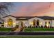 Elegant home with charming exterior, beautifully landscaped grounds and warm lighting at 20177 E Via De Arboles --, Queen Creek, AZ 85142