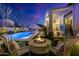 Nighttime view of a firepit and patio seating area with a pool in the background at 20177 E Via De Arboles --, Queen Creek, AZ 85142