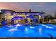 Luxury pool with blue lighting, fountains, and lounge chairs at night at 20177 E Via De Arboles --, Queen Creek, AZ 85142