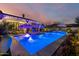 Blue illuminated rectangular pool with fountains and patio umbrellas at night at 20177 E Via De Arboles --, Queen Creek, AZ 85142